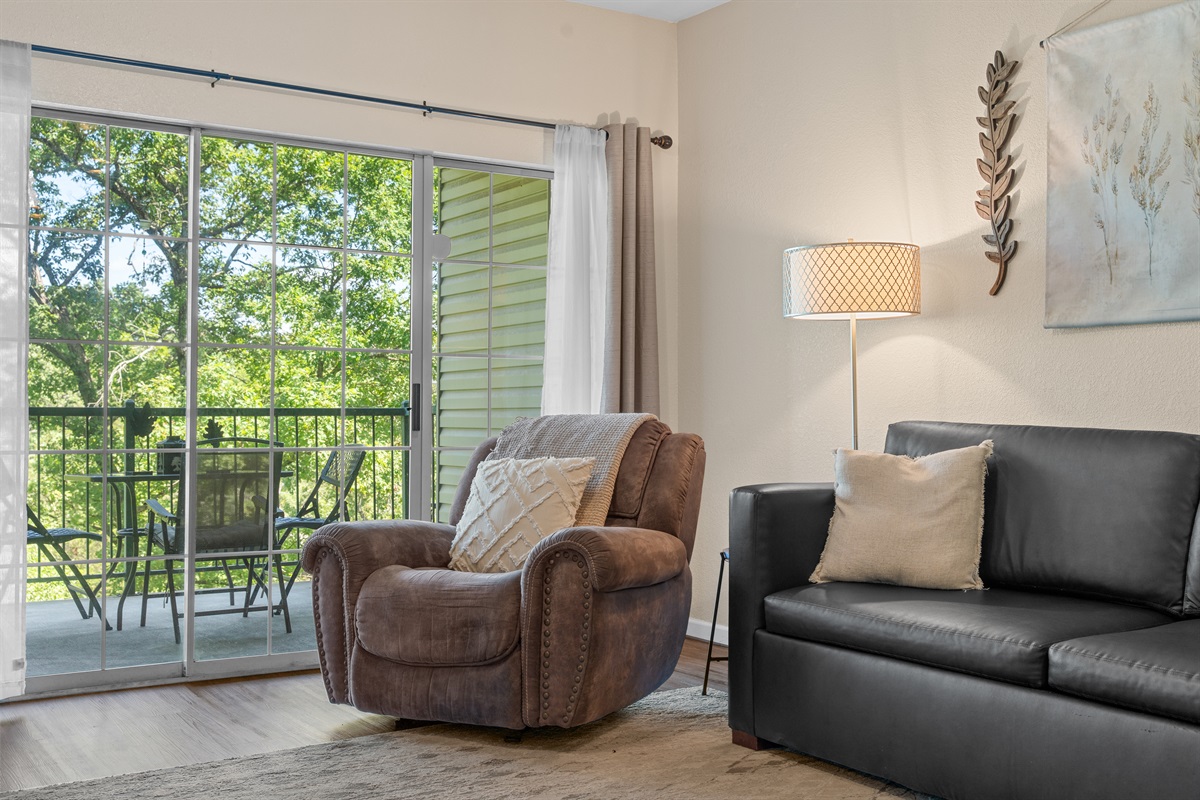 Cozy chair by the sliding door creates a sunny corner for reading or a quiet cup of coffee.