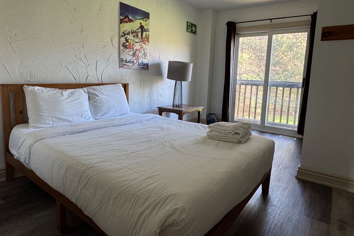 Bedroom #1 with view of the beautiful backyard and forest
