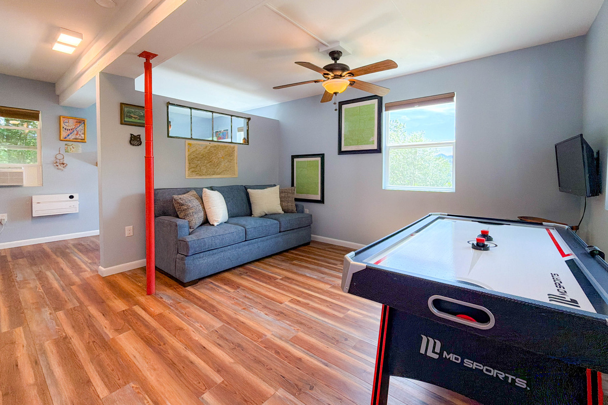basement game room featuring an air hockey table, Smart TV, sitting area.
