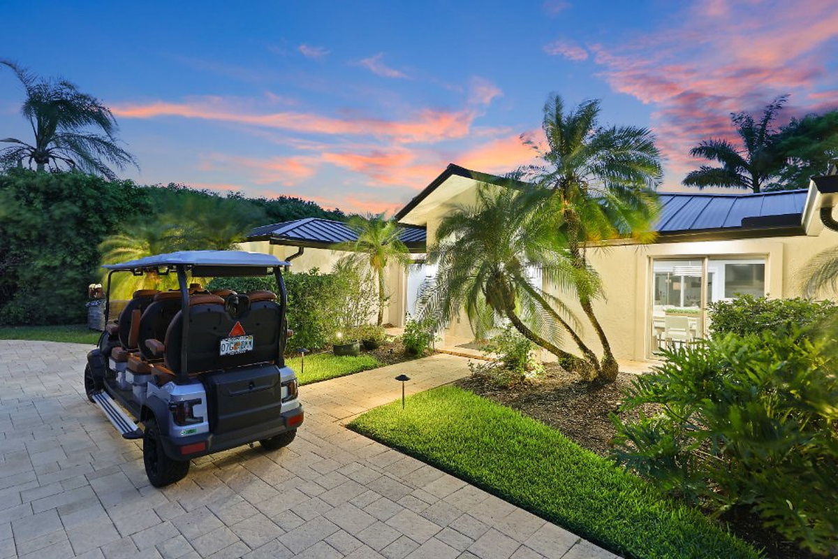 Golden-hour palms, a welcoming entry, and the golf cart create a memorable arrival moment at Oasis Palms.