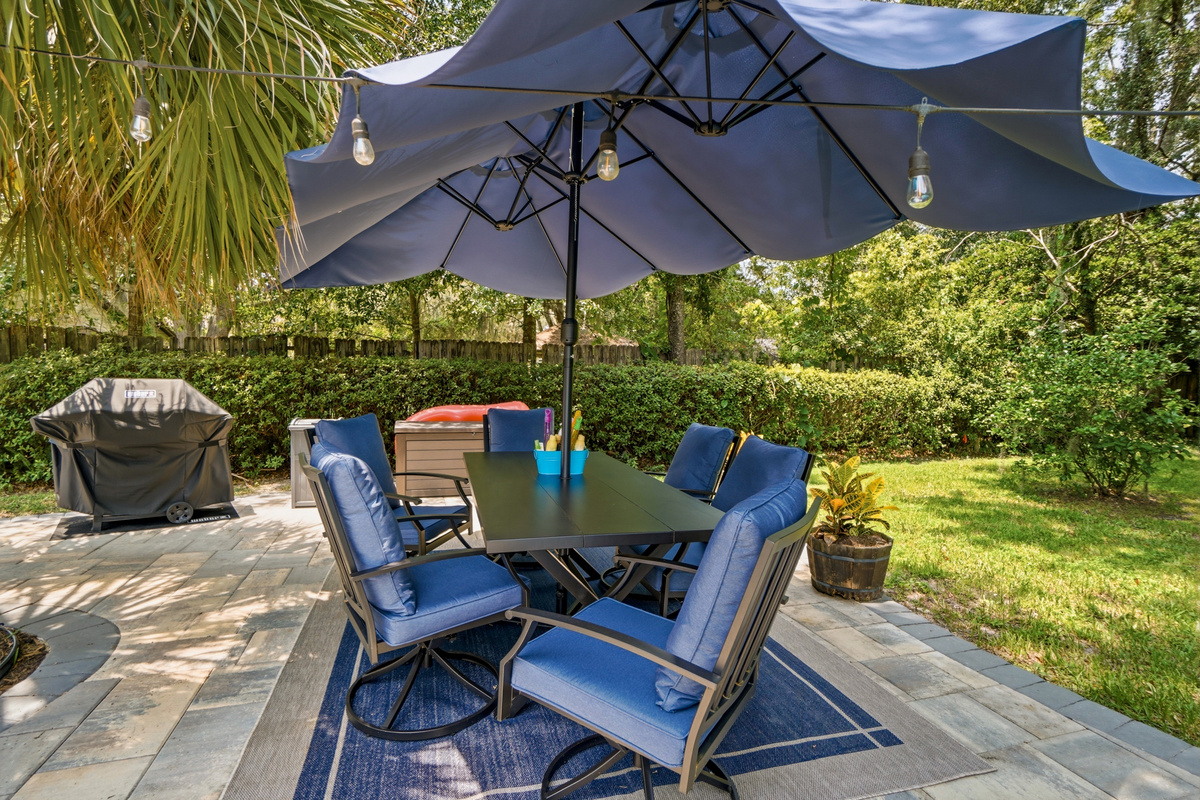Enjoy outdoor meals beneath the oversized umbrella with seating for the whole group.