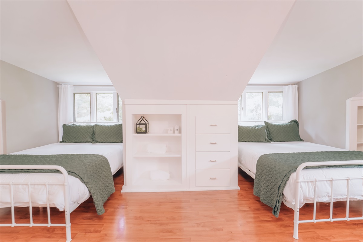 A retreat of its own. The secluded upstairs bedroom features two queen beds, a dedicated work space, and is where you will find the delightful sunroom. There is built in shelving and closet space for guests to utilize.