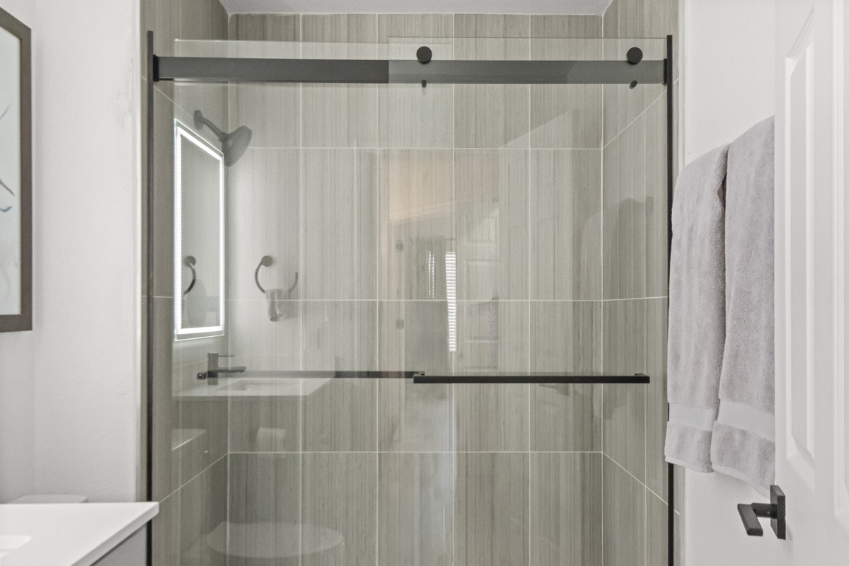 Modern walk-in shower with glass doors and a clean, contemporary design.
