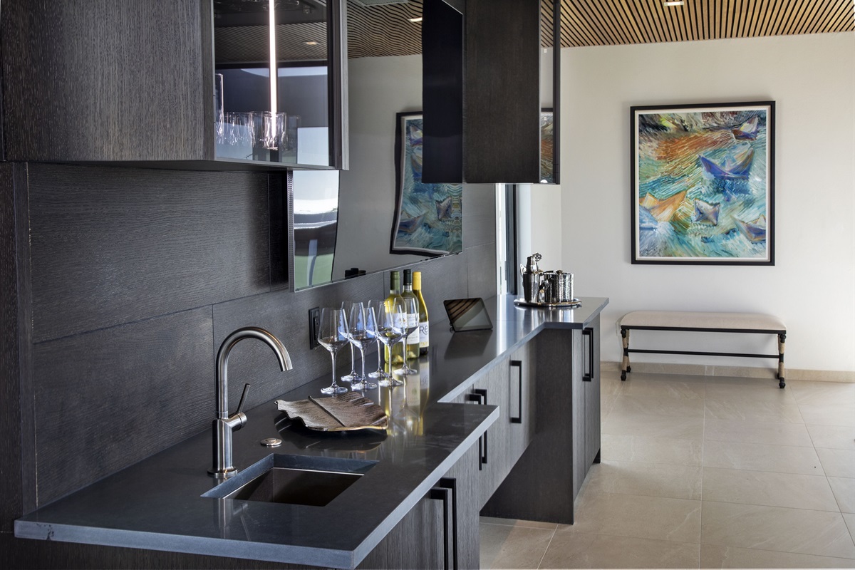 Just under the massive living room TV is the wet bar with sink, ice maker and fridge. It makes drink refills when you're lounging in the hot tub a breeze!