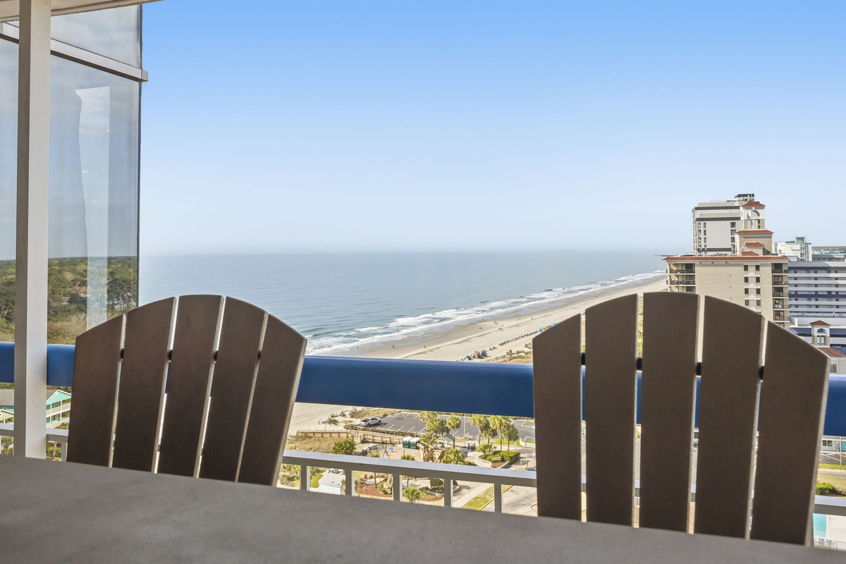 Covered balcony with Adirondack chairs and wide Atlantic views from the 17th-floor penthouse