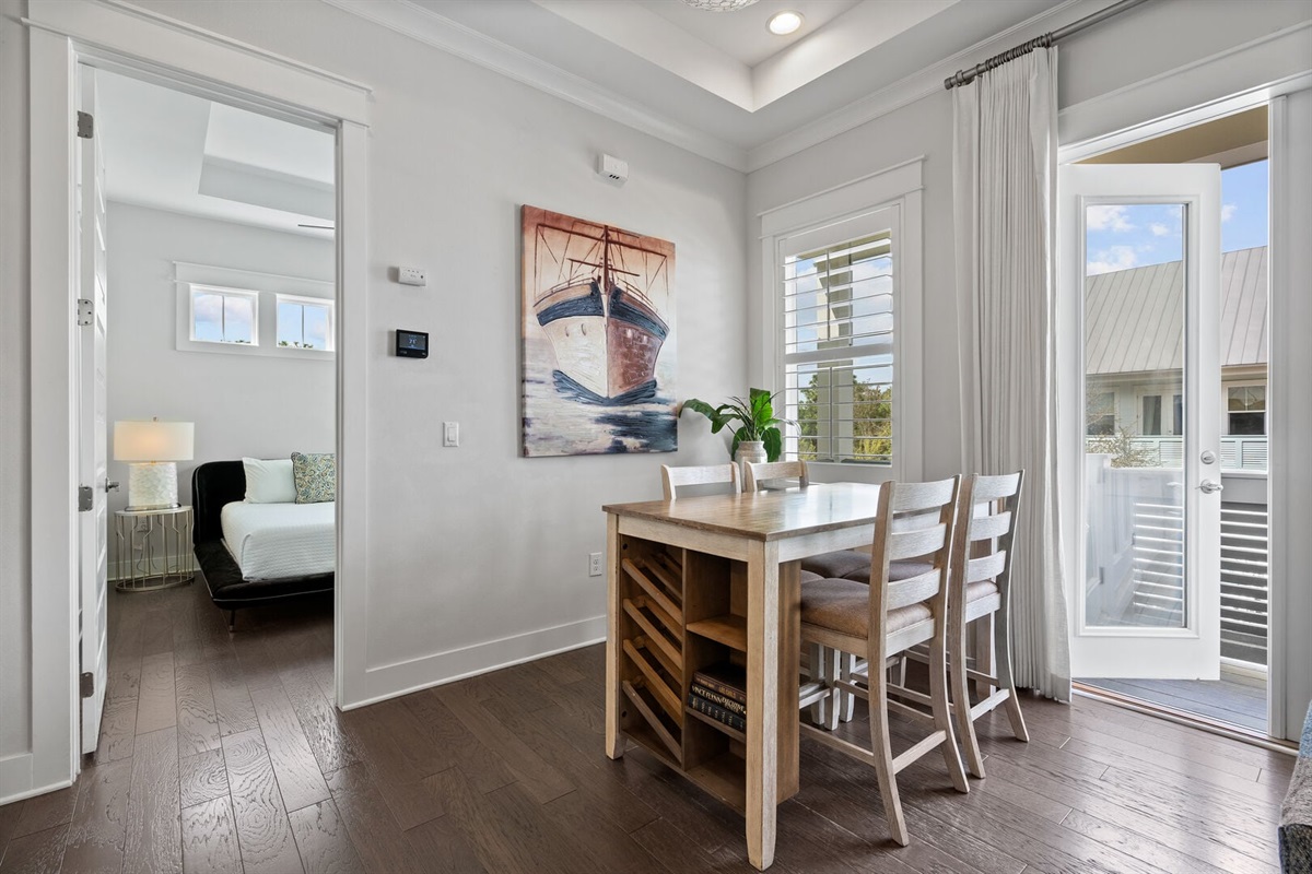 Dining nook seats four with coastal artwork.