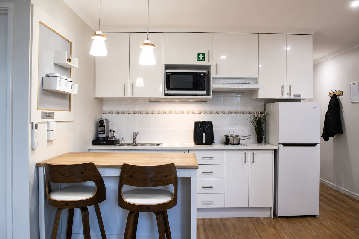 The kitchenette includes a fridge, microwave, sink, coffee maker and dining table, giving Sea Breeze Apartment practical self-contained convenience.