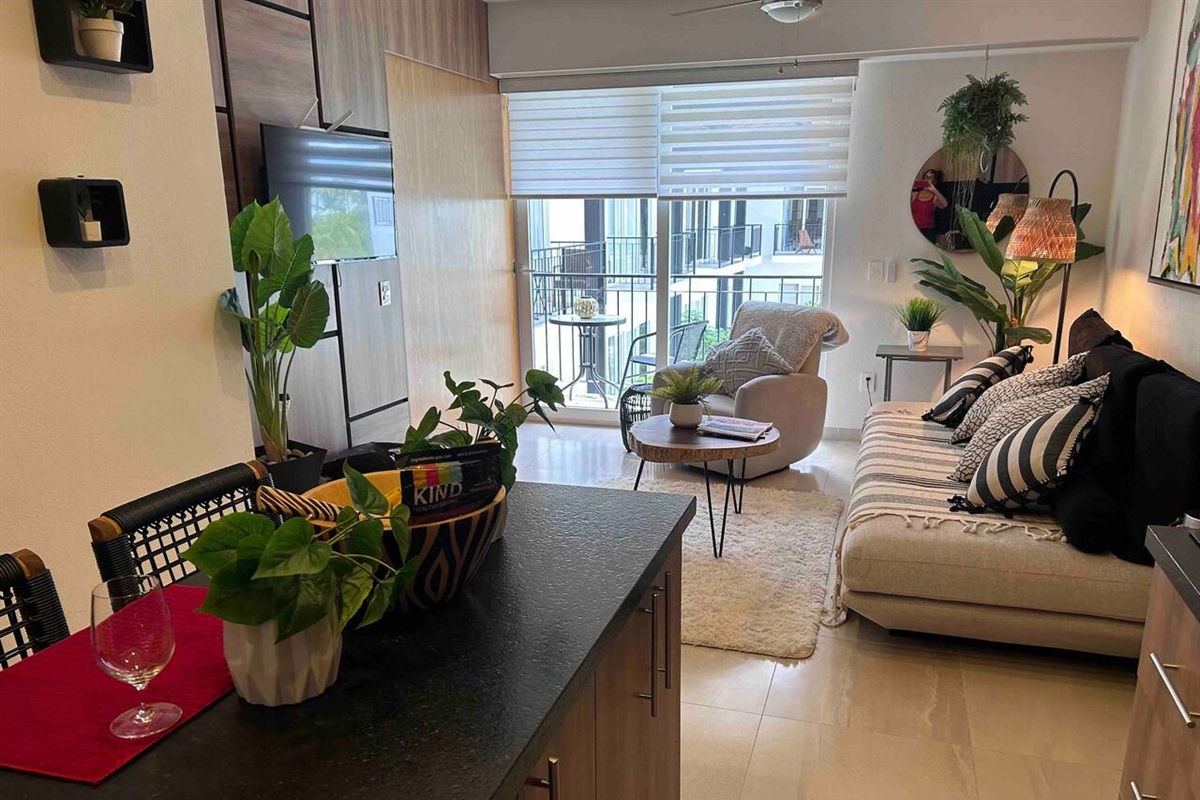 Living room looks out to the pool with a peek of the ocean