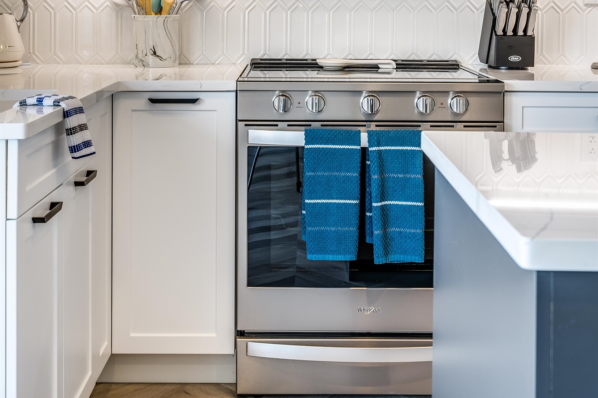 Fully equipped kitchen with stainless steel electric stove/oven combo.