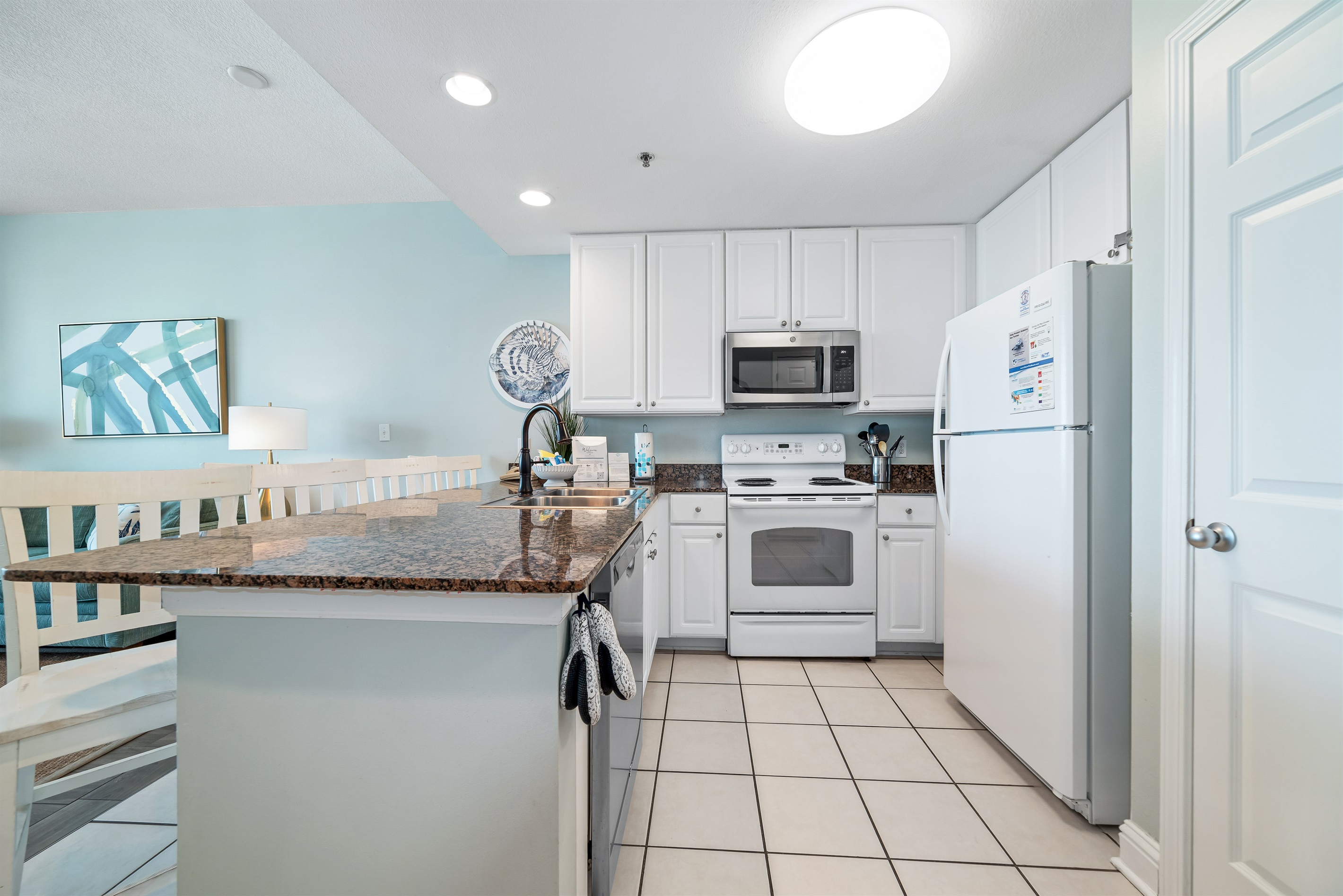 This fully functional kitchen boasts stainless steel appliances, sleek countertops, and ample cabinet storage, ideal for everyday cooking and entertaining.