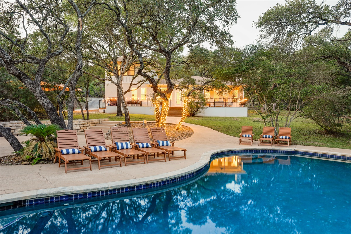 This serene pool area offers a generous deck, shaded seating, and a glowing ambiance that’s perfect for afternoon swims or evening relaxation.