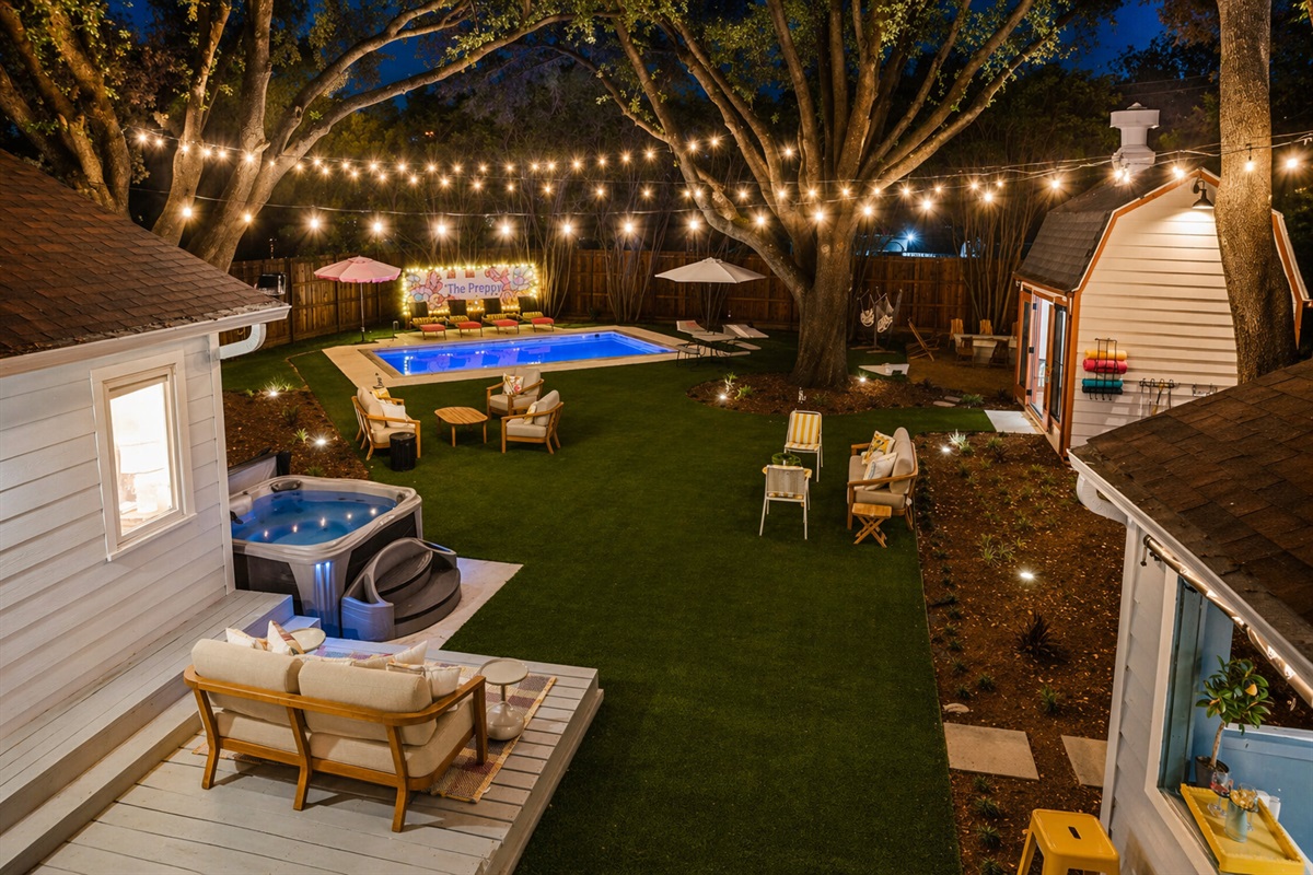 Hot tub, sport pool, teak lounge seating, putting green and pool house all under a canopy of string lights. The Preppy backyard at twilight. The ultimate Fort Worth group retreat. Yours all week.