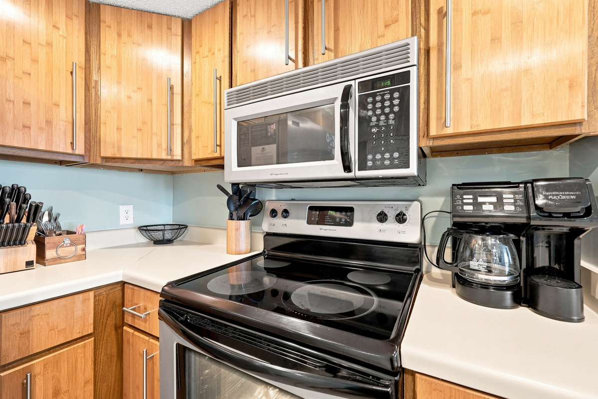 Kitchen essentials at your fingertips, including a microwave, smooth-top stove, and coffee maker.