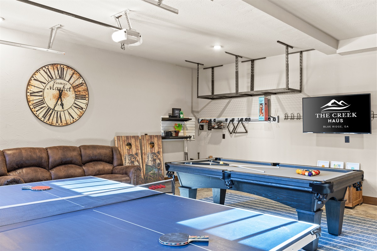 Game room has a cozy and inviting vibe! Some highlights are the pool table and ping-pong tables, corn hole, life-size games and a comfortable couch with smart TV for watching the game.