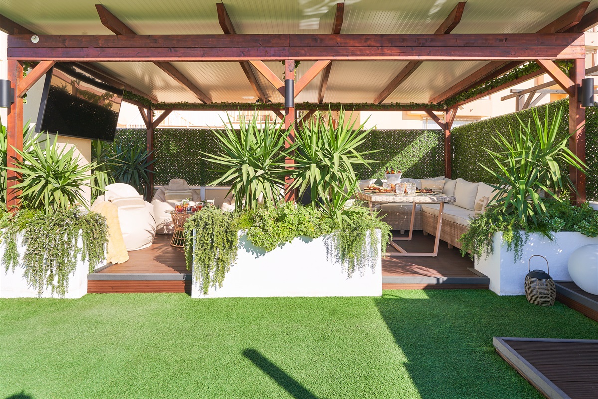 Relax beneath the covered pergola with cozy seating, fireplace, and dining area. Perfect for long evenings, romantic dinners, or movie nights on the outdoor TV under soft ambient lights.