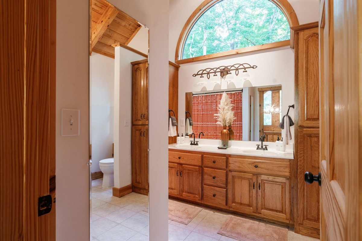 Large upstairs bathroom with double vanity and shower tub combo.