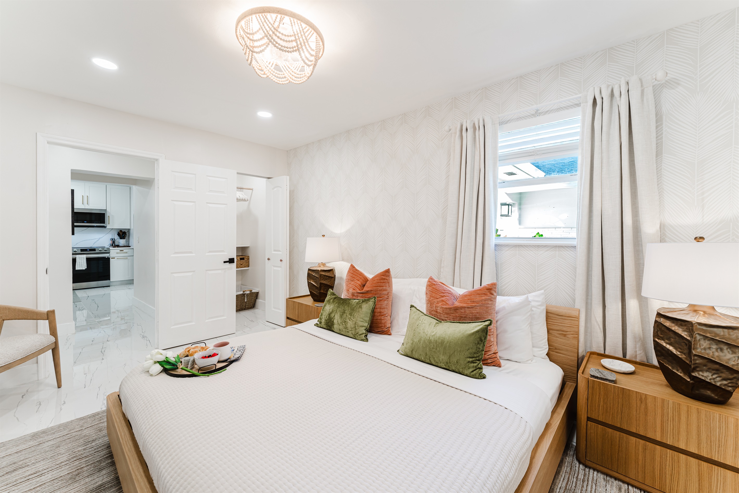 Primary king suite designed for rest and privacy, featuring fresh cotton linens, a Smart TV, and serene Palm Beach–inspired finishes. Includes a walk-in closet and private en-suite bathroom for a comfortable, hotel-style stay.