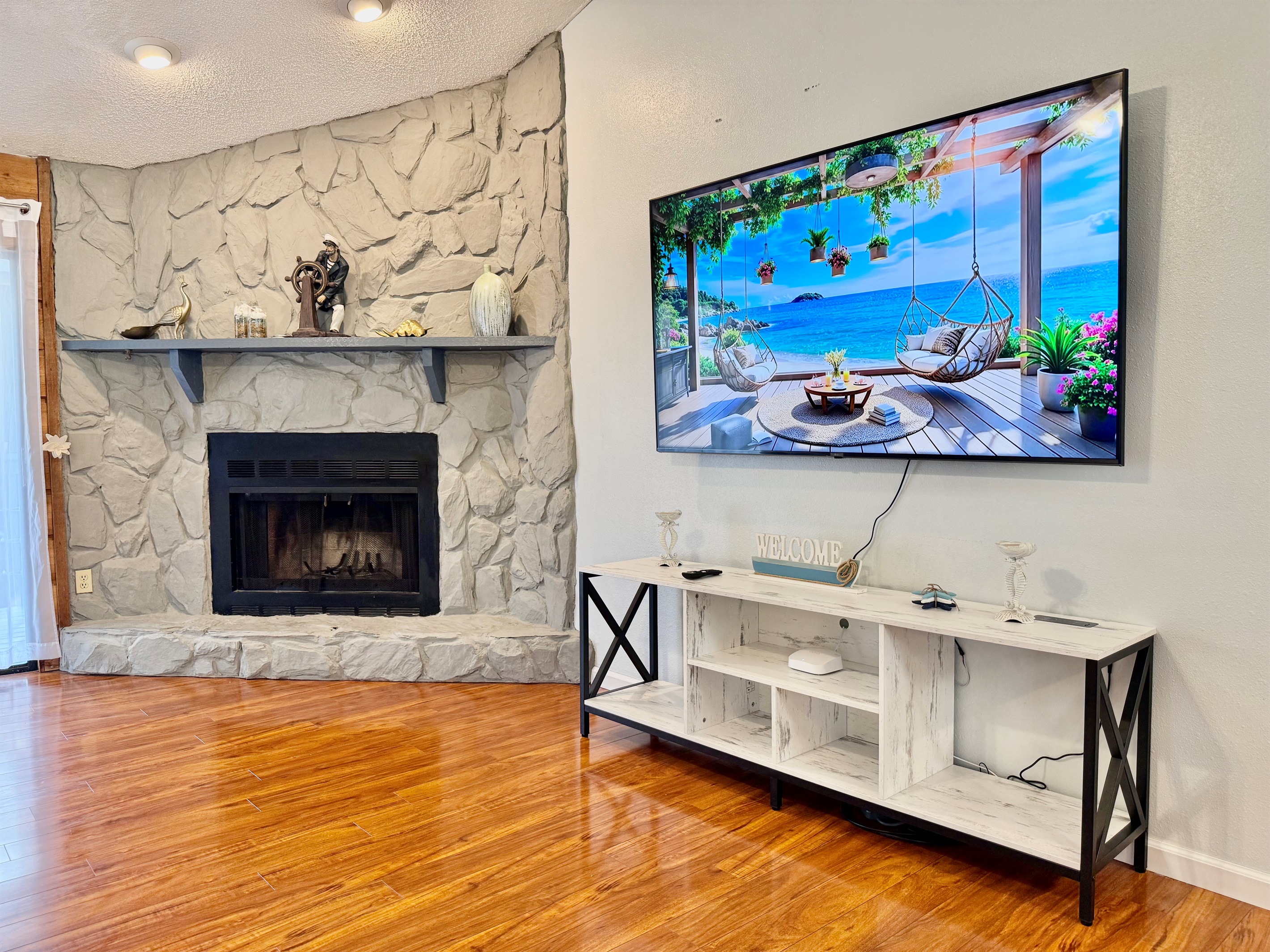 Anchoring the room is a stunning floor-to-ceiling stone fireplace, creating a rustic focal point that exudes coziness and character.