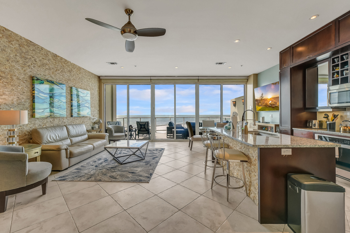 Large 200 sq-ft living area with sleeper sofa, indoor dining, and fully-equipped kitchen with island and granite countertops.