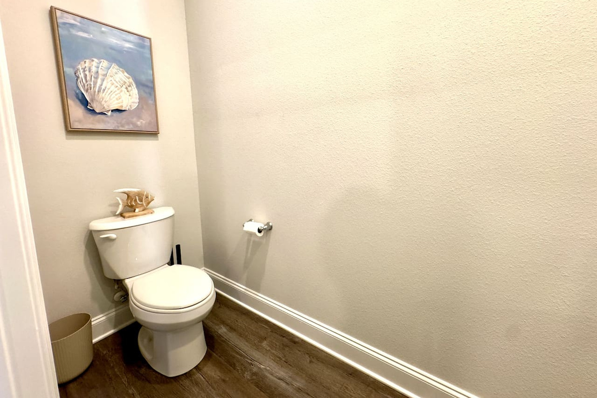 Tucked-away and quiet, wood floor cool underfoot. Coastal artwork catches your eye, a moment of calm privacy.