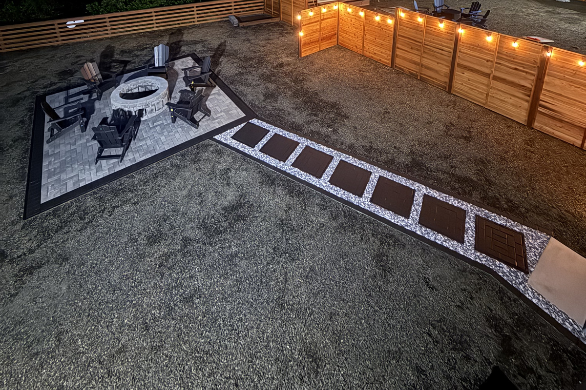 Watch the string lights flick on at dusk — the fire pit keeps glowing long after sunset, and the lit paver path walks you right back to the door.