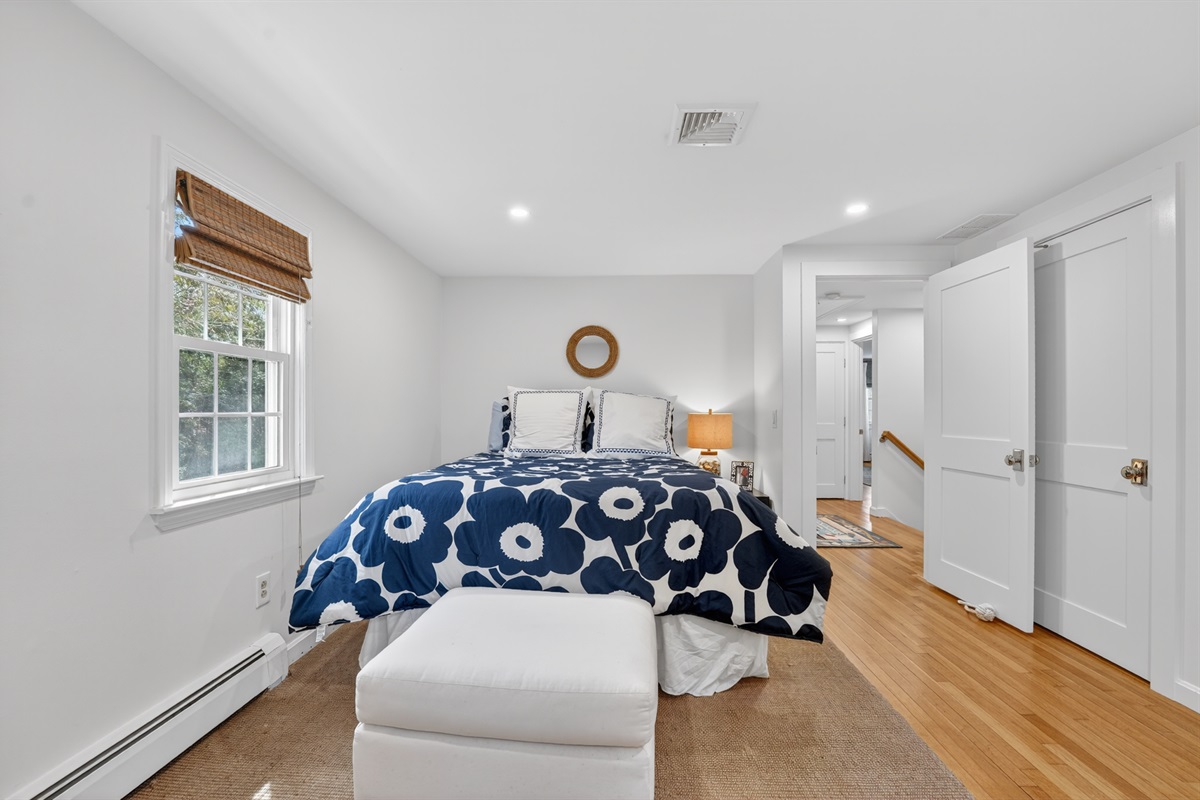A peaceful first bedroom featuring a soft queen bed.