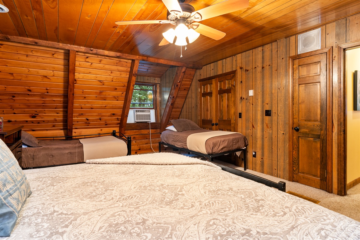 Bedroom #4 Inviting bedroom with a King, 2 double beds and an additional twin, rustic wood walls, and a comfortable, homey atmosphere.
