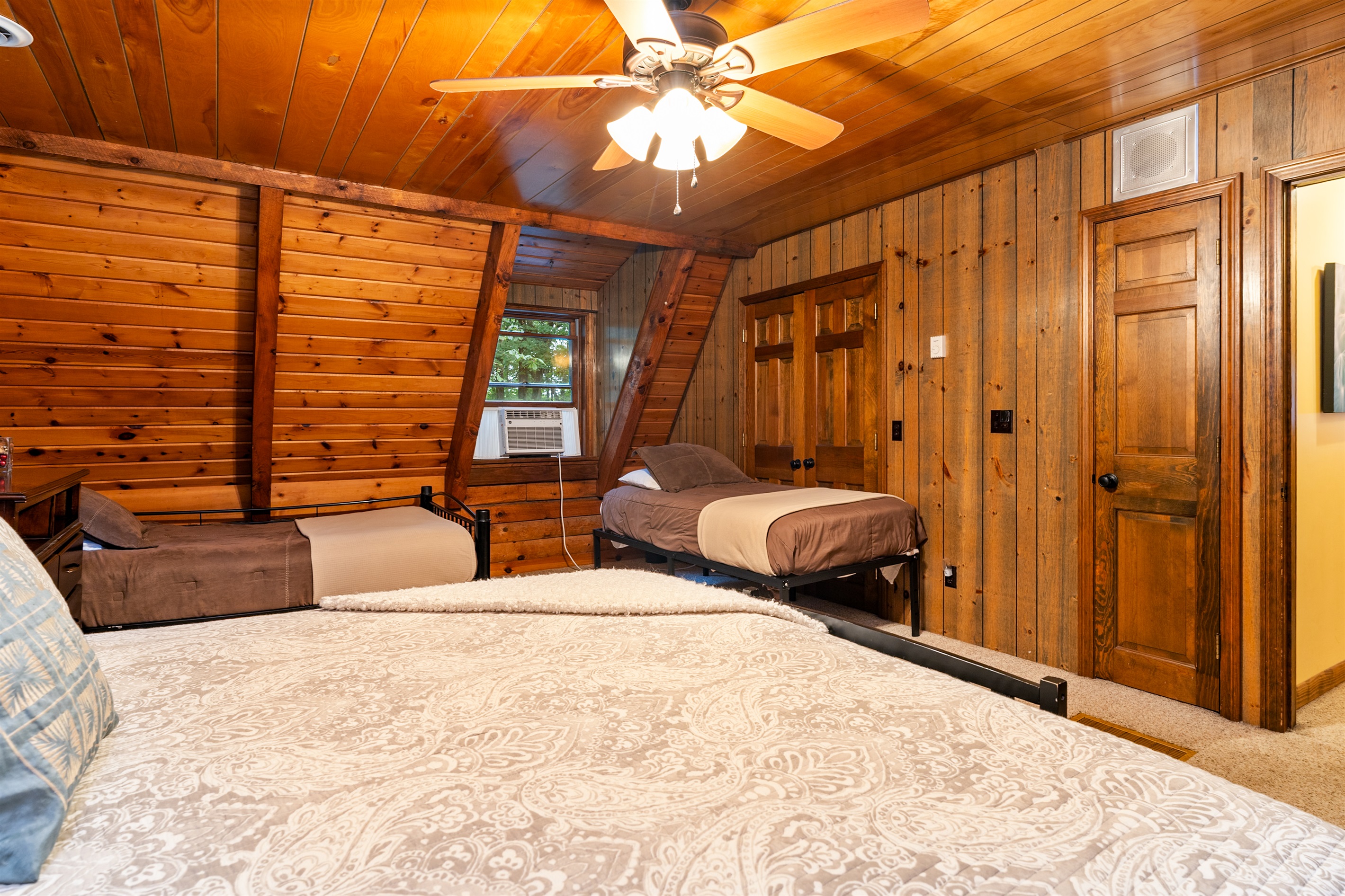 Bedroom #4 Inviting bedroom with a King, 2 double beds and an additional twin, rustic wood walls, and a comfortable, homey atmosphere.