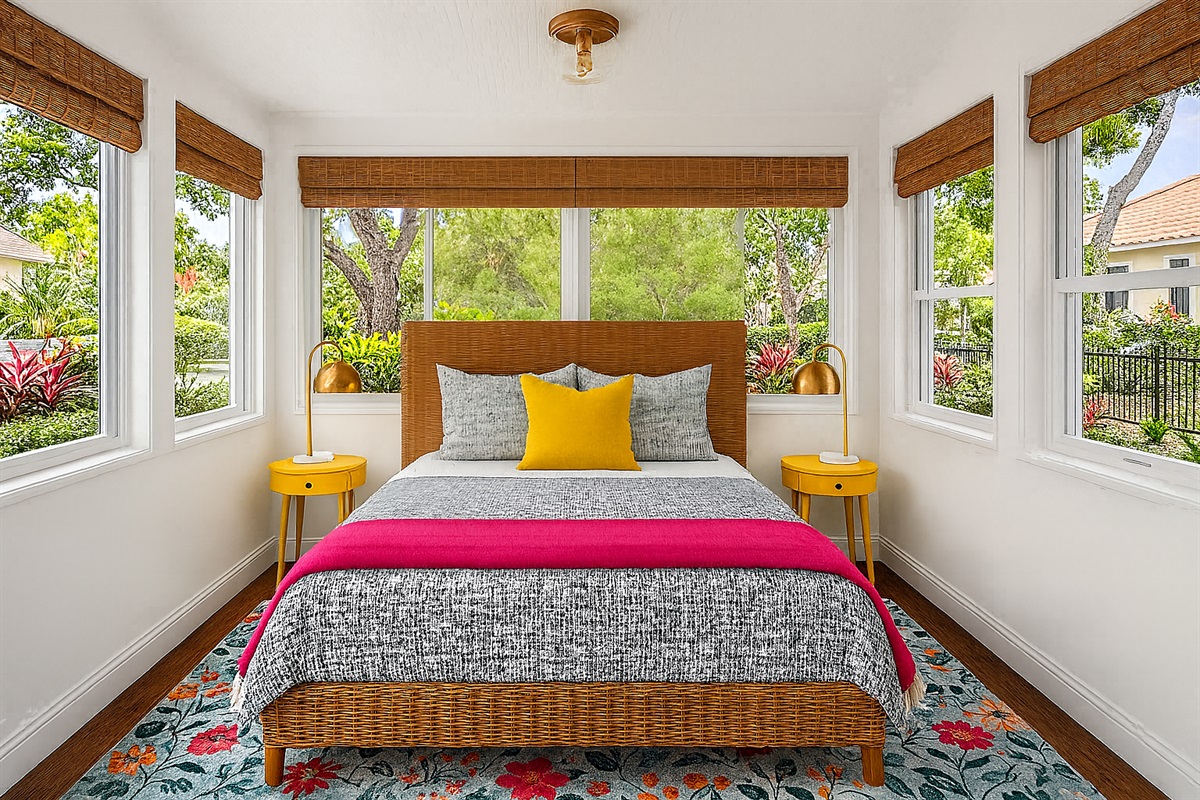 Updates (AI Generated pending new photos): Charming first-floor queen bedroom just off the main living area, featuring a queen bed, a smart TV, playful pineapple lamp, bamboo shades, and French doors that fill the room with natural light.