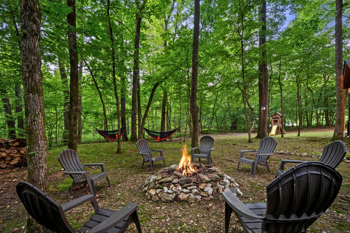 Campfire ring with Adirondack chairs in a peaceful wooded setting — ideal for storytelling and s’mores.
