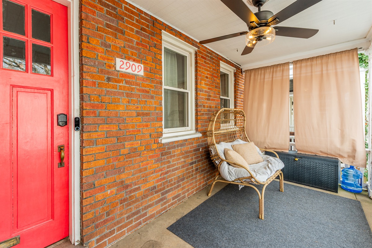 Inviting Porch Oasis: Relax on the rattan chair with a view! Perfect for morning coffee moments.
