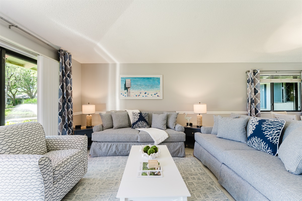 Bright and spacious coastal-inspired living room with oversized seating, Smart TV, cable, and direct access to the patio and outdoor dining area.
