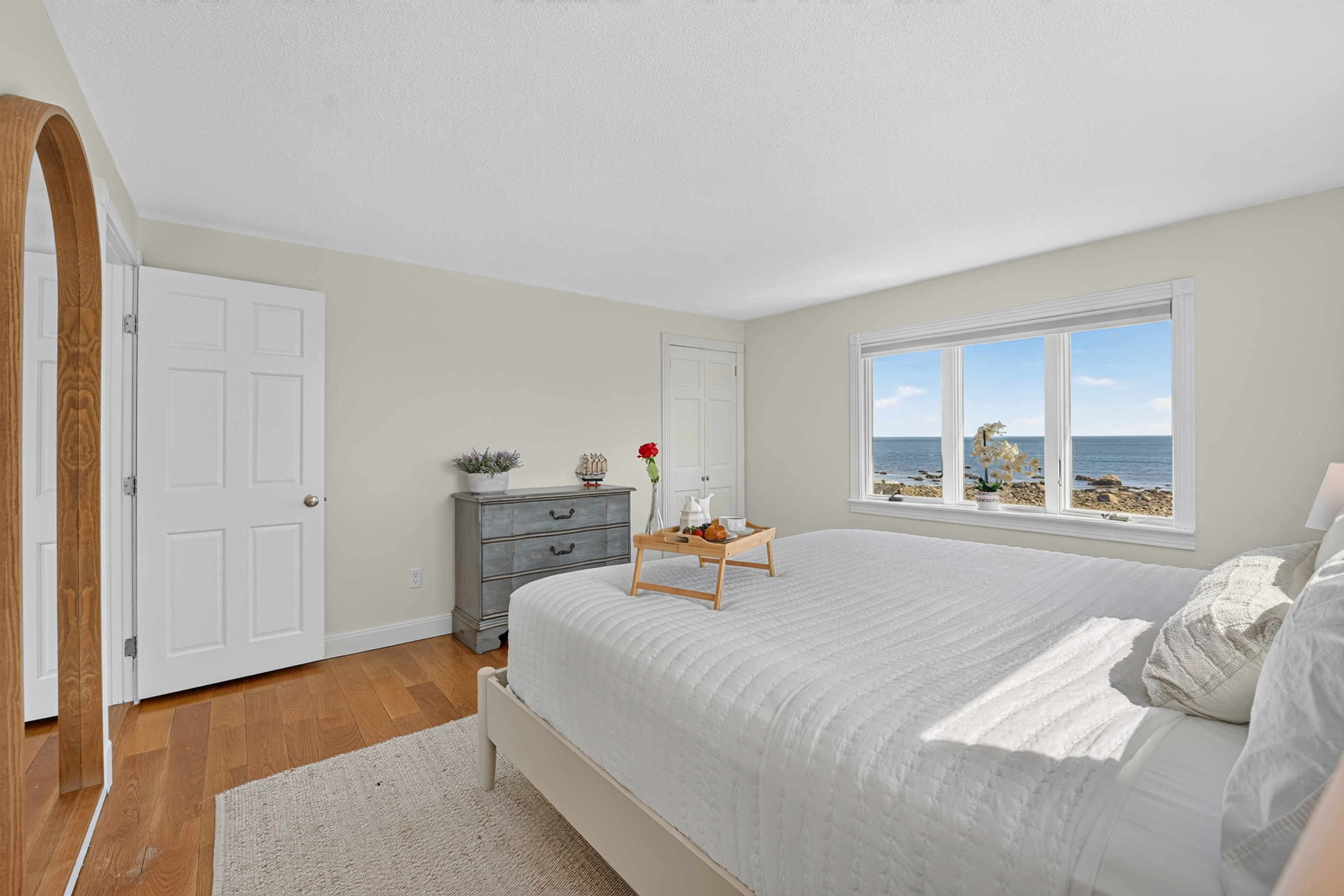Wake up to beautiful coastal scenery from this comfortable, light-filled bedroom.
