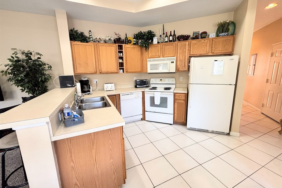 Spacious kitchen with plenty of cabinet storage, full-size appliances, a breakfast bar, and an open layout that flows into the dining and living areas.