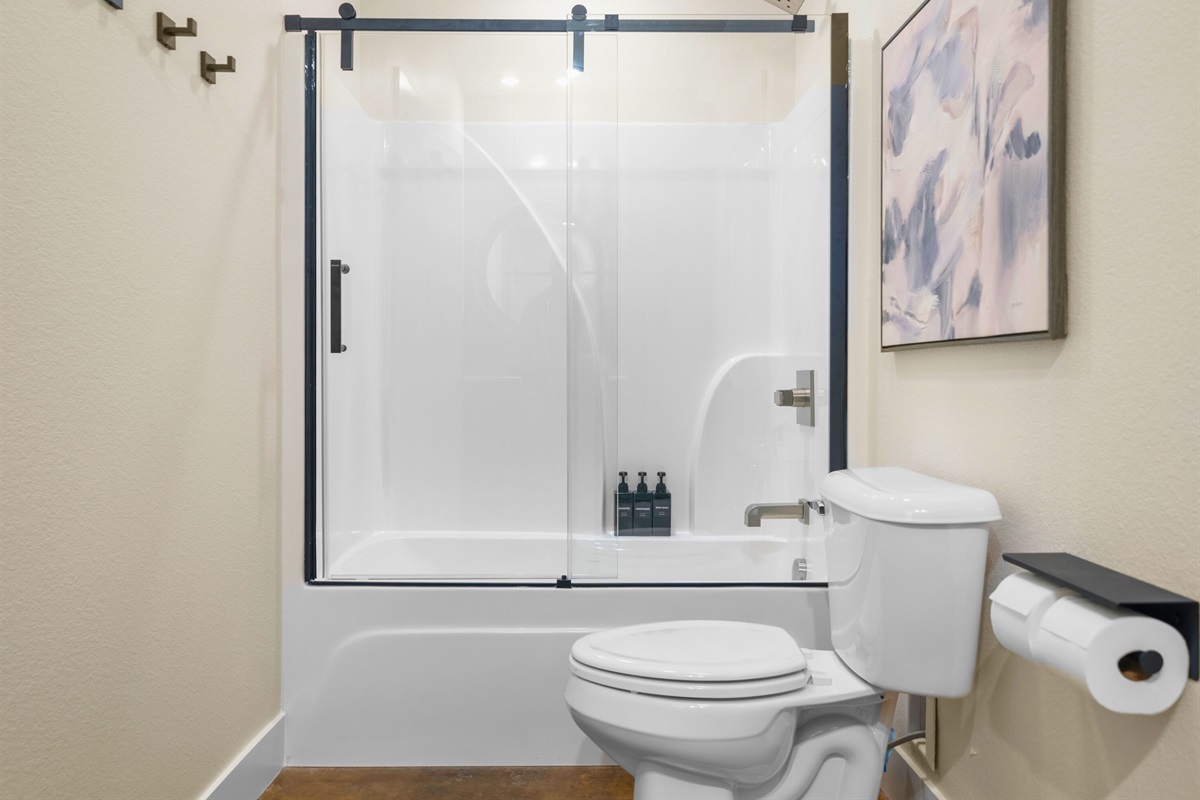 A clean and modern shower-tub combo makes this bathroom practical and comfortable for guests of all ages.