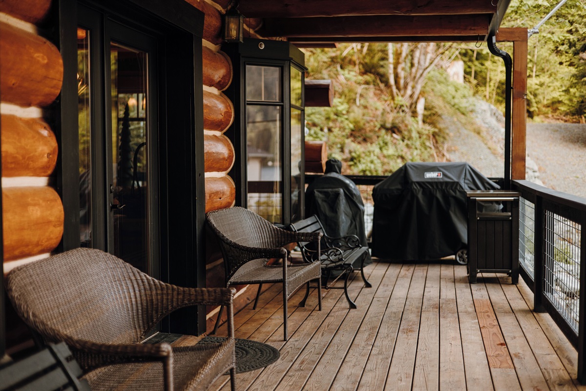 The main deck offers stunning views of the lake, complete with a barbecue grill and seating.