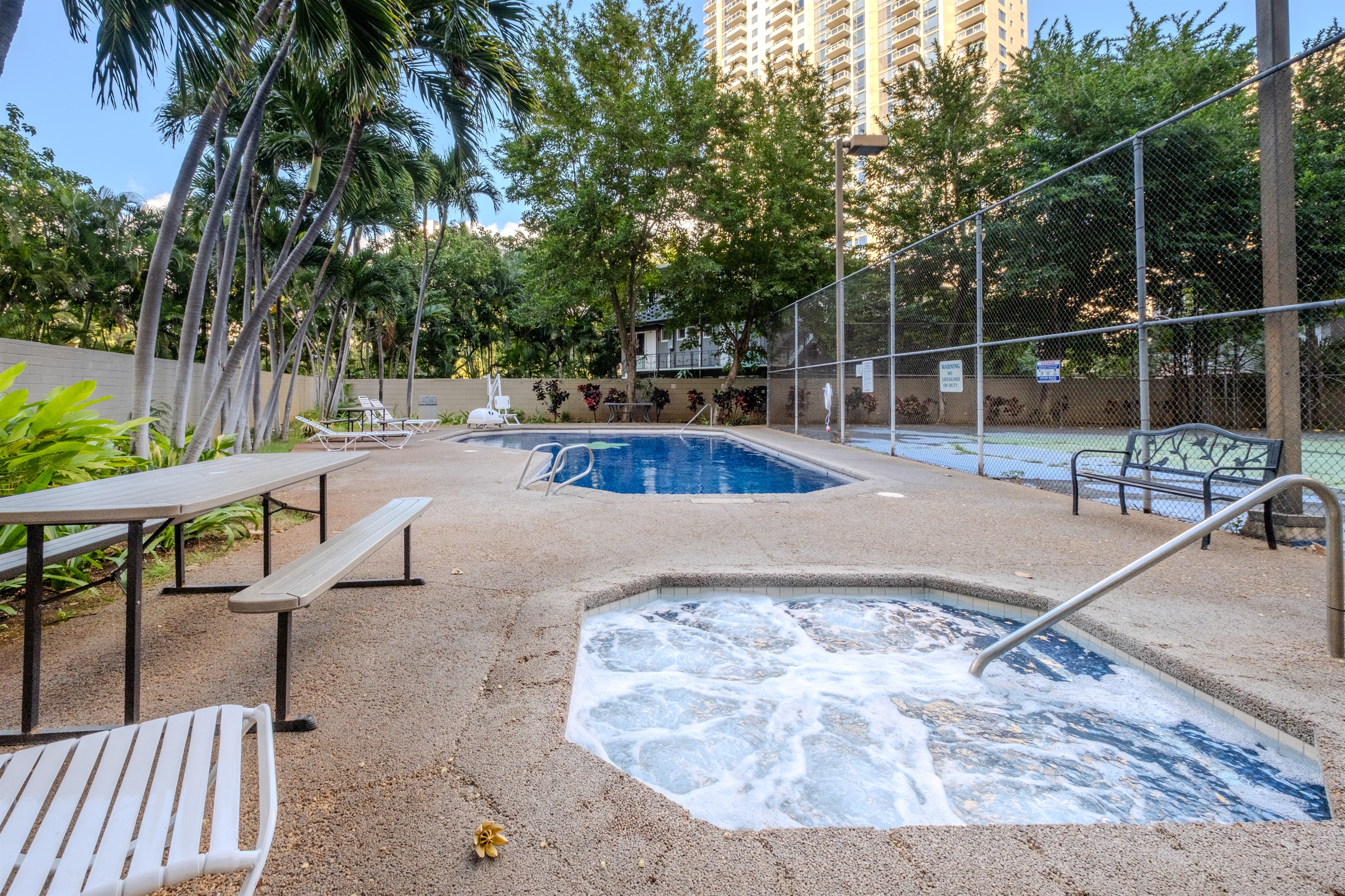 “Unwind in paradise — enjoy a refreshing swim or a soothing soak surrounded by lush palms and island breezes. This peaceful Waikīkī pool and jacuzzi area offers the perfect balance of relaxation and tropical charm.
