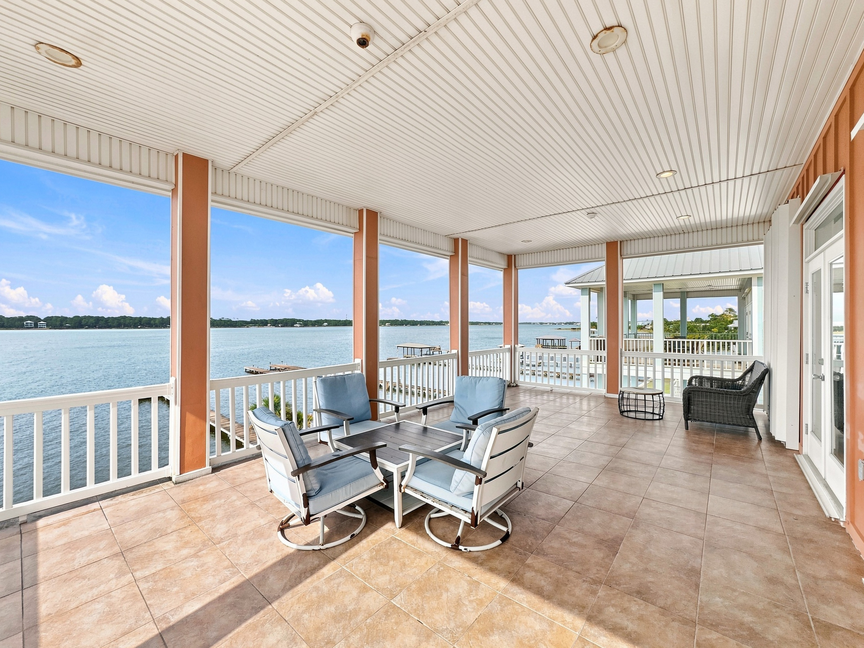 Covered waterfront porch with lounge seating overlooking Little Lagoon