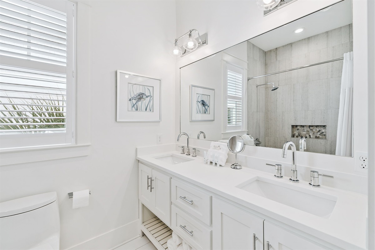 Second- floor bathroom features double vanities and a tub/shower combo