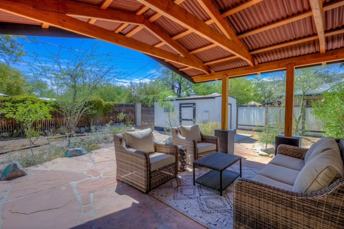 Large back deck with lounge area and mature vegetation