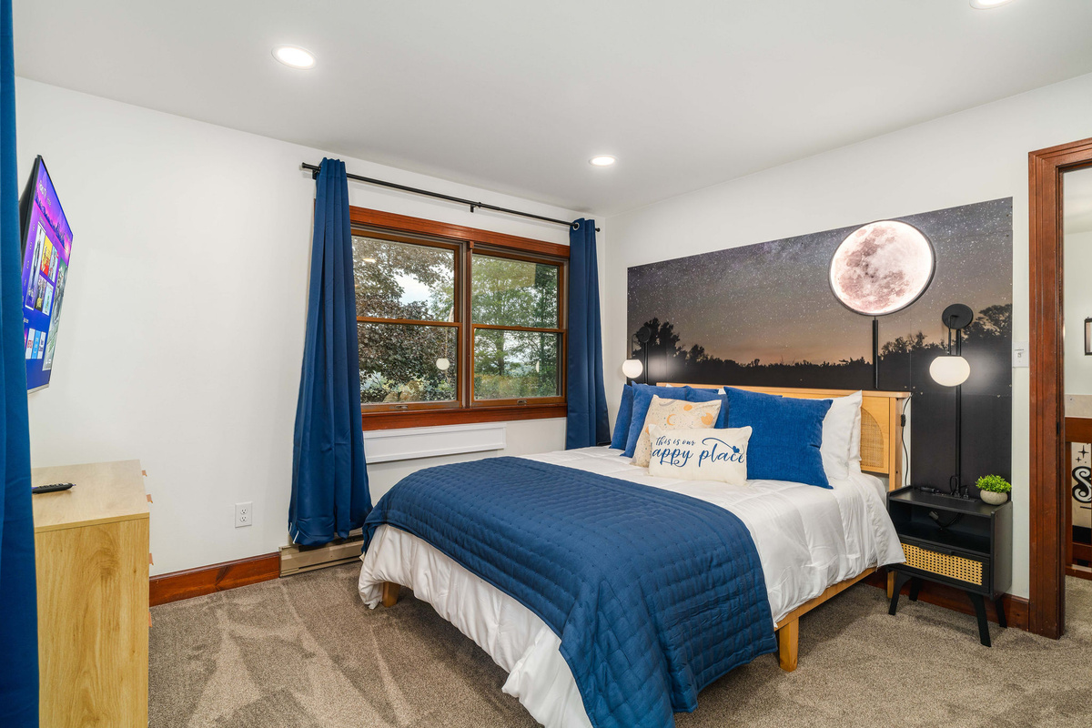 🌙 Moon Room: queen bed, 55" HDTV, and a moonrise mural over the headboard.
