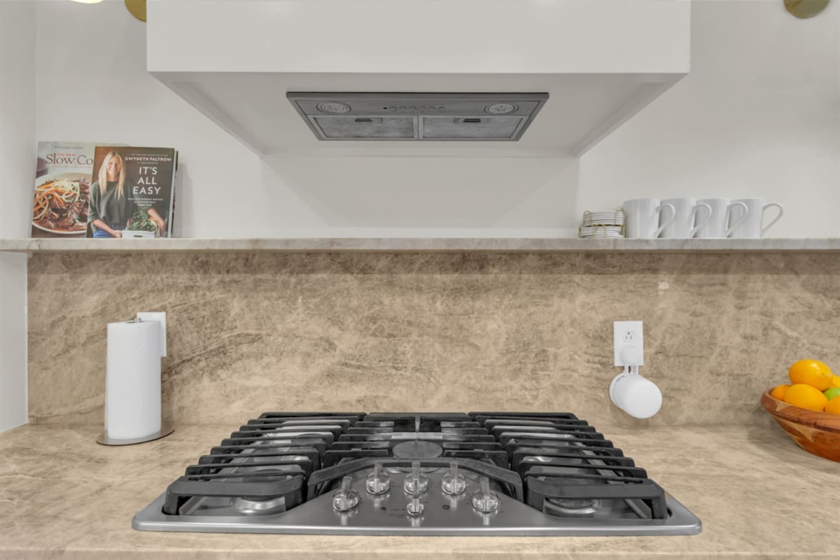 Five-burner stainless steel gas stove, perfect for cooking full meals with ease during your stay.