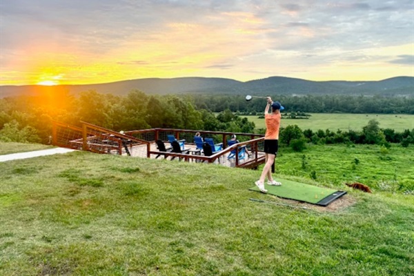 Golf driving mat overlooking the valley—aim for the island below if you’re feeling bold (guest photo - June 2025).