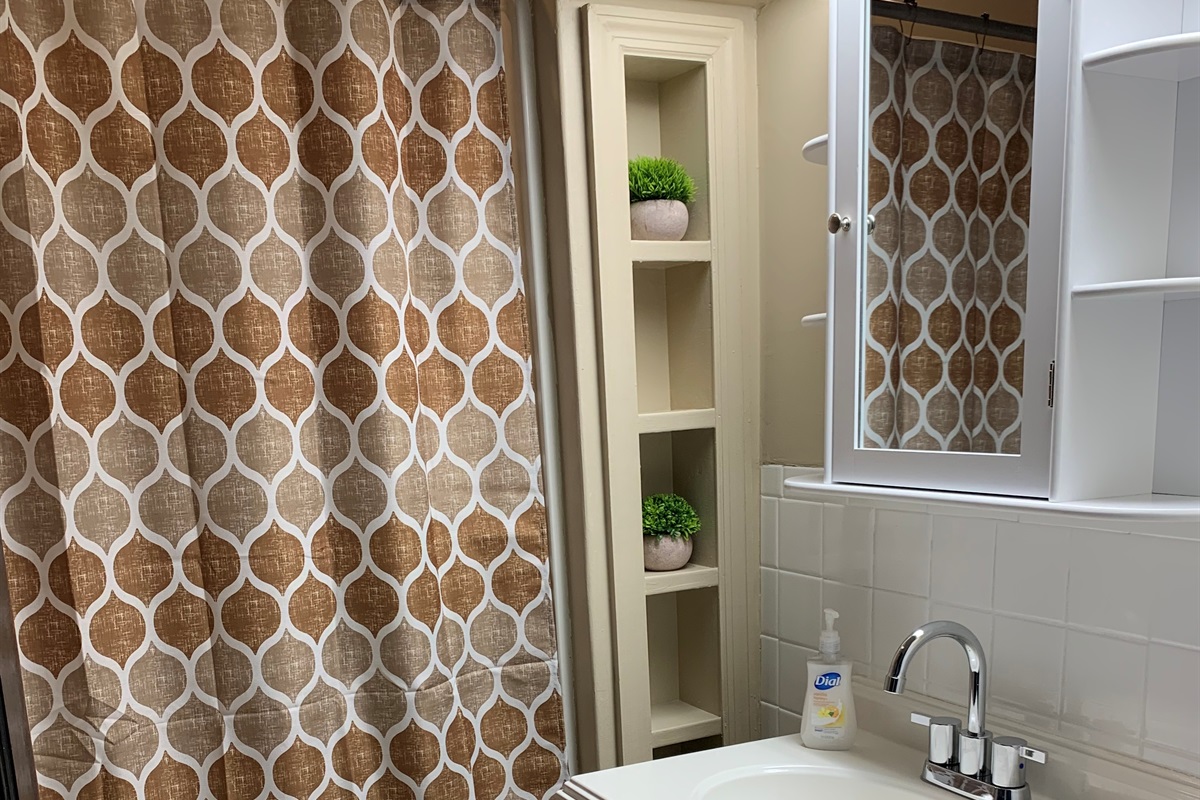 The bathroom has a shower/tub combo.