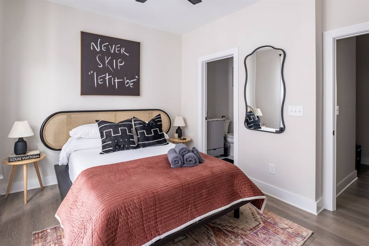 A thoughtfully designed queen suite with private ensuite access and a TV perfectly positioned for relaxing evenings&mdash;featuring plush pillows, soft linens, and a ceiling fan for optimal comfort. Guests consistently rave about the beds.