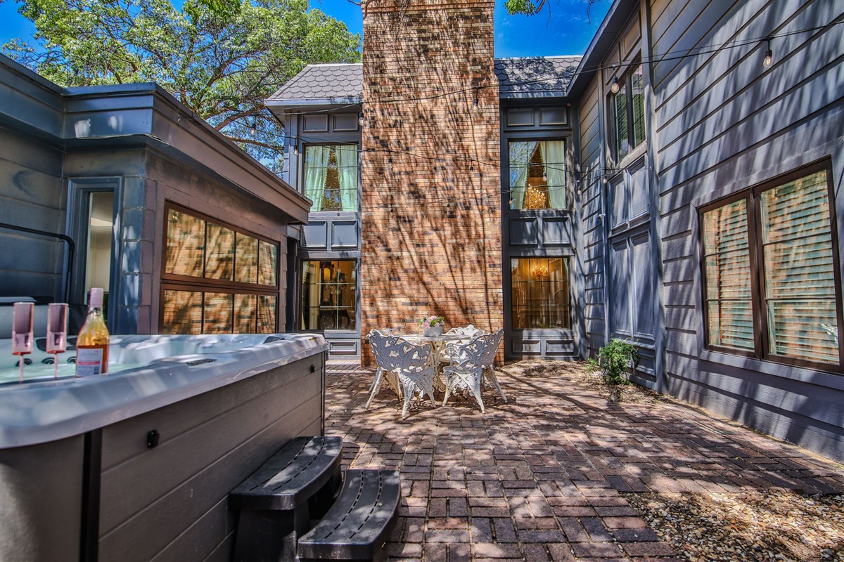A cozy courtyard with seating for four, perfect for morning tea or moonlit confessions. A steaming hot tub awaits—just the thing after a promenade or tête-à-tête.