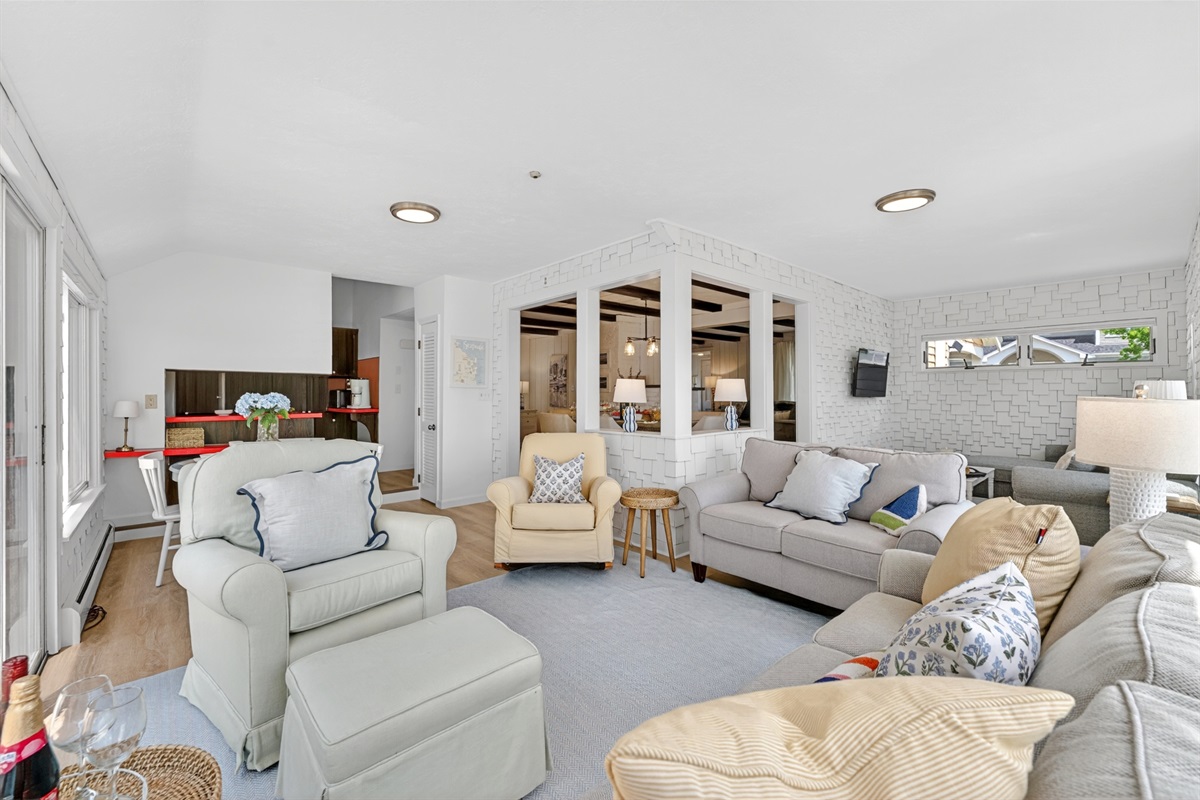 Spacious living room with large windows that bring in plenty of sunlight, highlighting a comfortable lounge space perfect for relaxing or gathering.