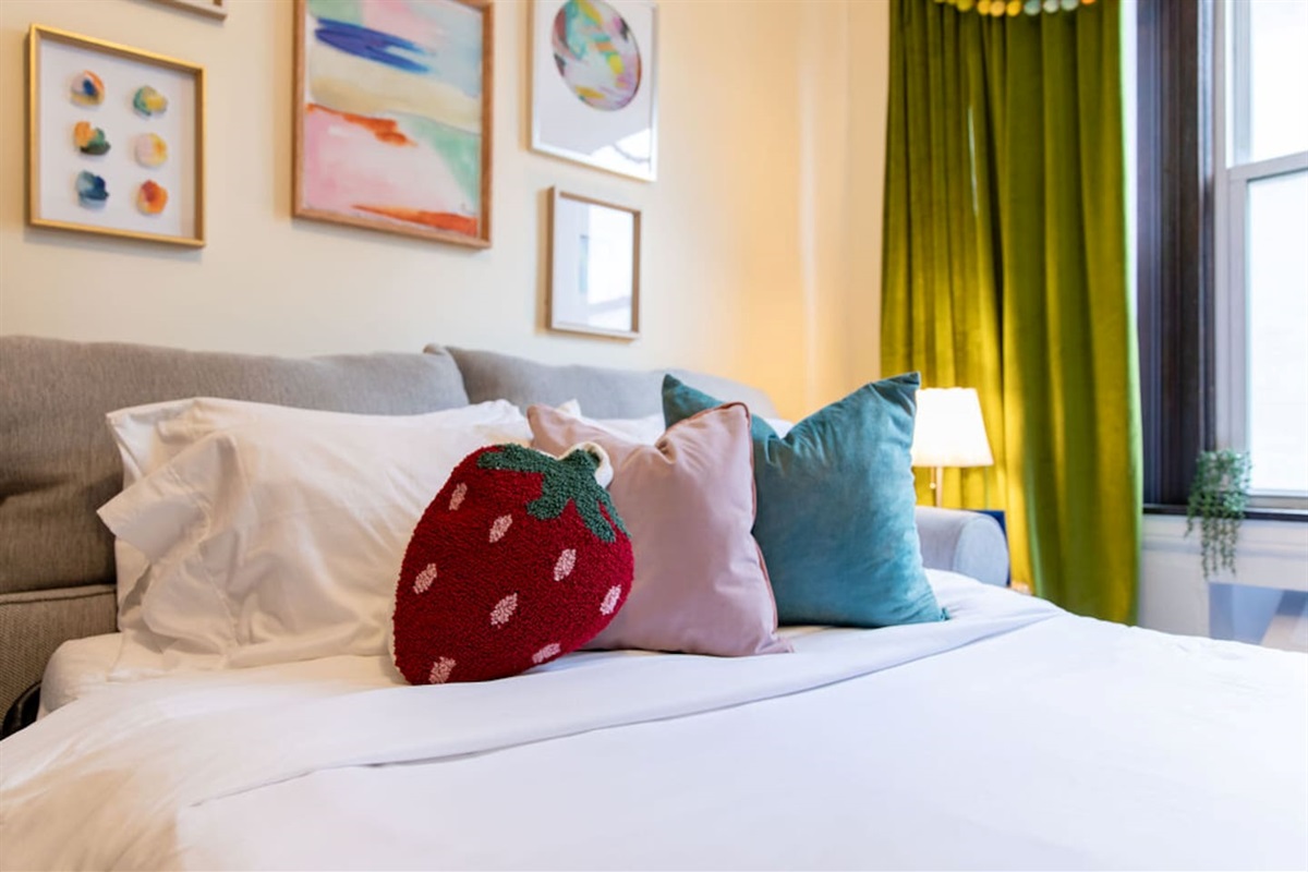 Bright and spacious living room featuring a comfortable sofa bed, perfect for relaxing or accommodating extra guests.