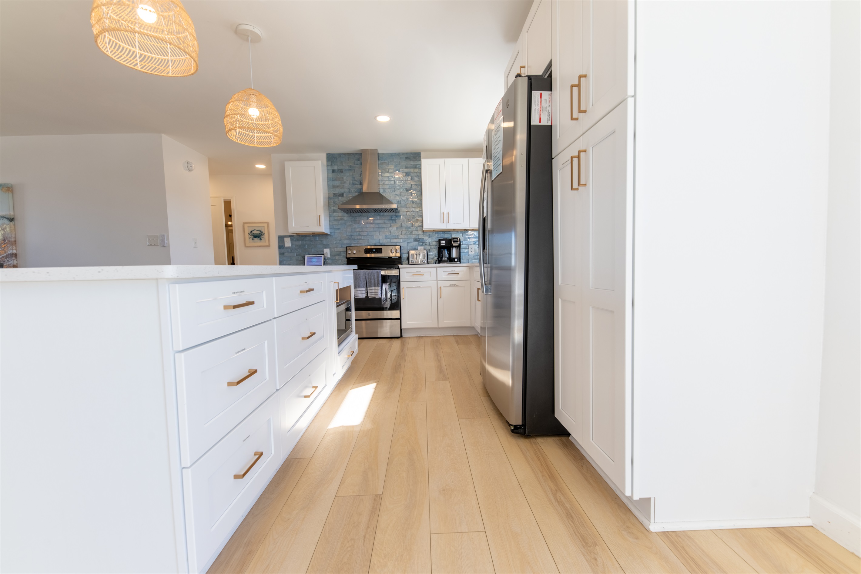 Cooking is a pleasure in this bright, beautiful and well-stocked kitchen that includes a large island, plenty of cabinet space, a pantry for your groceries, and beautiful wave-like tiles.