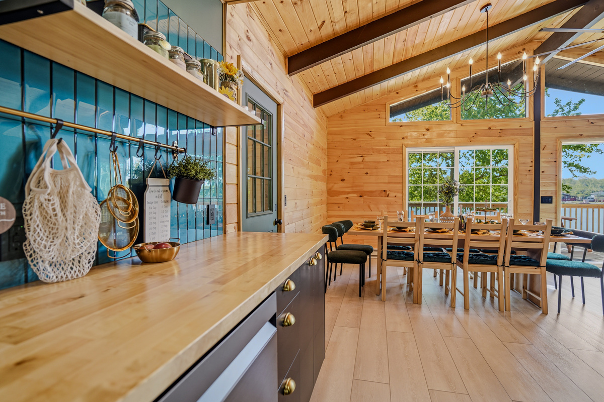Kitchen with wood countertops, open shelving, pot rack, and views through to the dining area